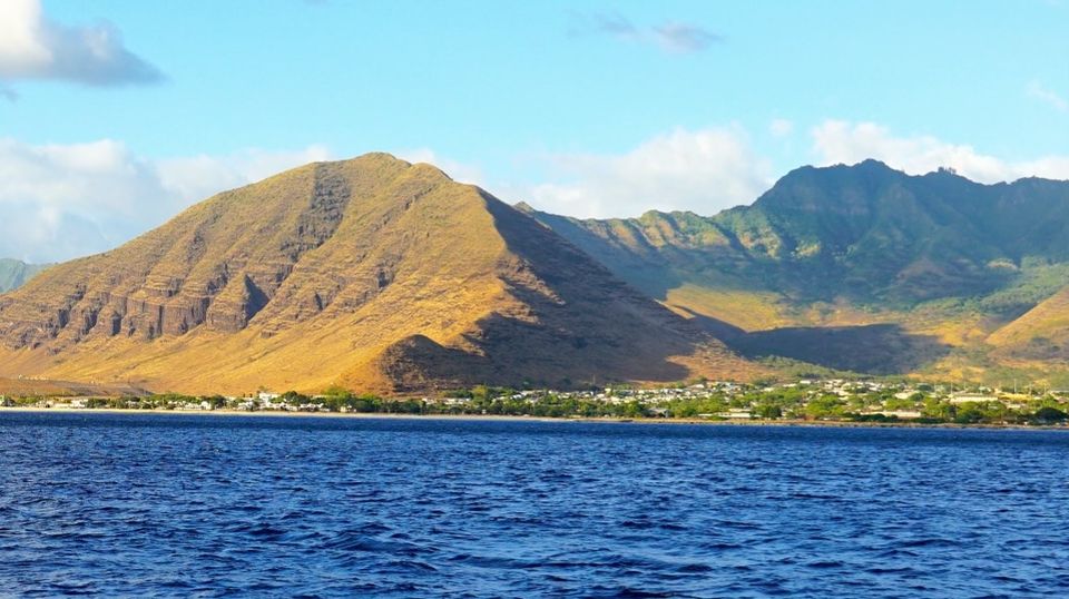 a large body of water with a mountain in the background