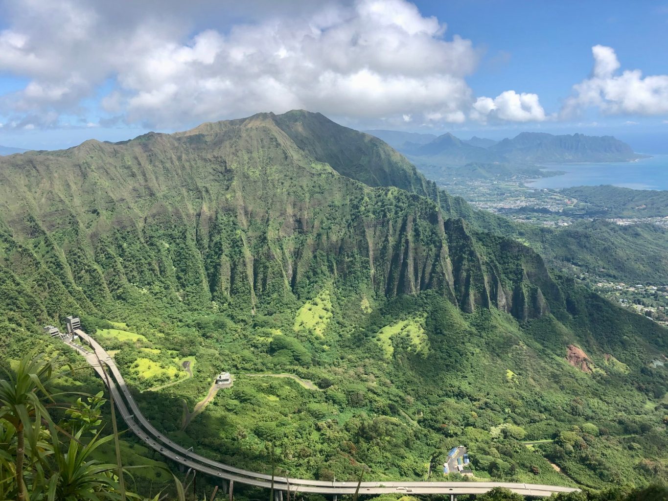 road traveling through a mountain range in hawaii