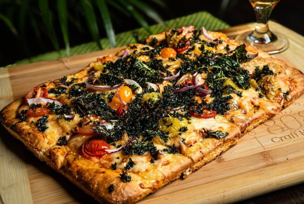 a pizza sitting on top of a wooden cutting board