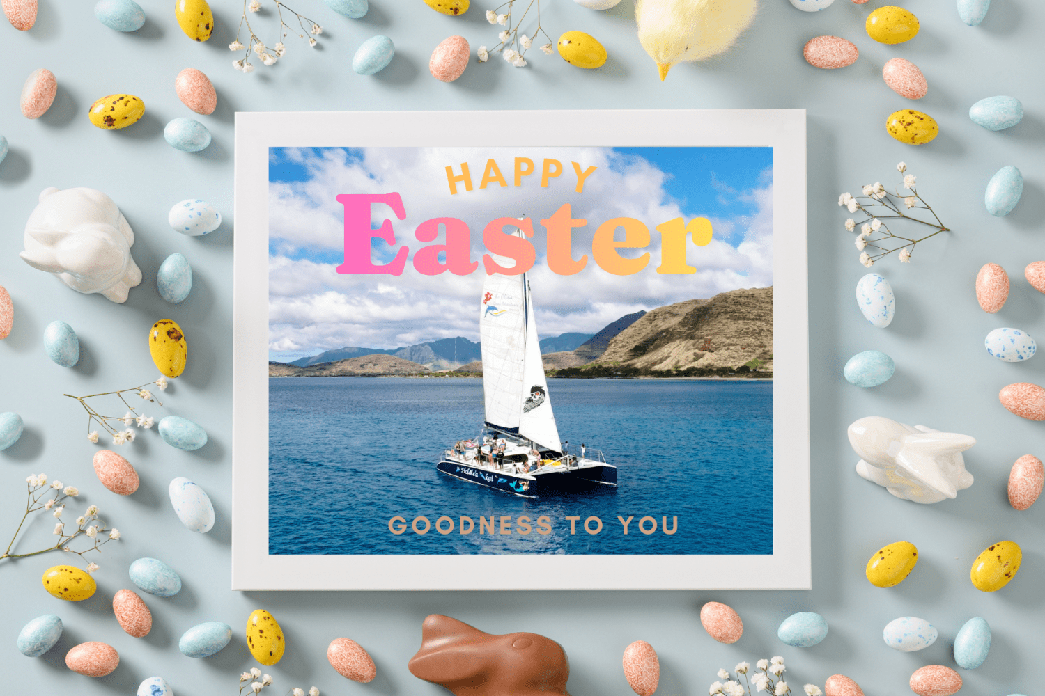 Sailboat on water in Easter-themed frame with colored eggs and text 'Happy Easter'.