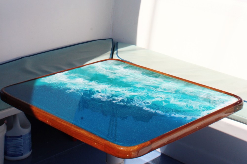 Tabletop with ocean wave image, boat seat in background.
